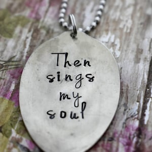 May include: A silver necklace with a pendant that says "Then sings my soul".