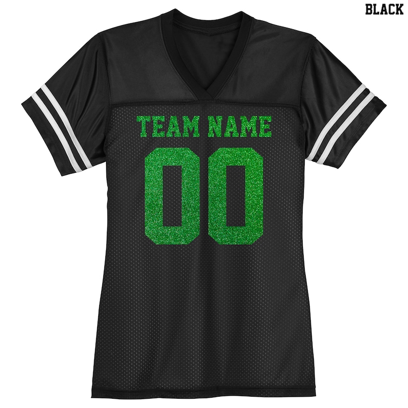 Puede incluir: Camiseta de f&uacute;tbol negra con rayas blancas en las mangas. La camiseta tiene un nombre de equipo y un n&uacute;mero "00" en purpurina verde.