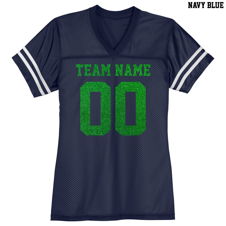 Puede incluir: Jersey azul marino con rayas blancas en las mangas. El jersey tiene cuello en V y el texto "TEAM NAME" y el n&uacute;mero "00" en purpurina verde.