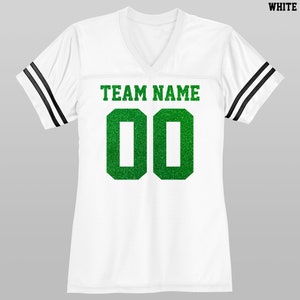 Puede incluir: Jersey blanco con mangas rayadas en blanco y negro. El jersey tiene un n&uacute;mero "00" de purpurina verde y el texto "TEAM NAME" en la parte delantera.