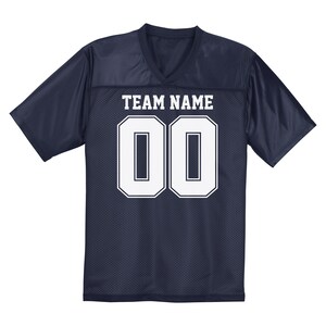 Puede incluir: Camiseta de f&uacute;tbol azul marino con tejido de malla blanca. La camiseta tiene un cuello en V blanco y n&uacute;meros blancos en la parte delantera. El texto "TEAM NAME" est&aacute; impreso sobre los n&uacute;meros.