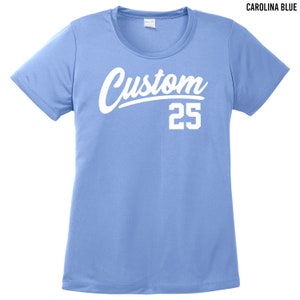 May include: A light blue t-shirt with a white custom design and the number 25. The text is in a bold, cursive font.