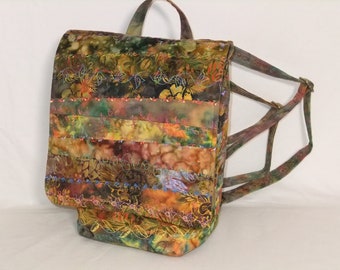 Quilted Backpack purse in the colors of fall.  Medium  backpack purse. Draw String closure w/ flap.  Zip Pocket inside and outside back.