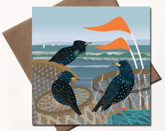 May include: Three black and white starlings perched on a beach scene with orange flags and blue waves. The birds are perched on a brown and tan woven net.