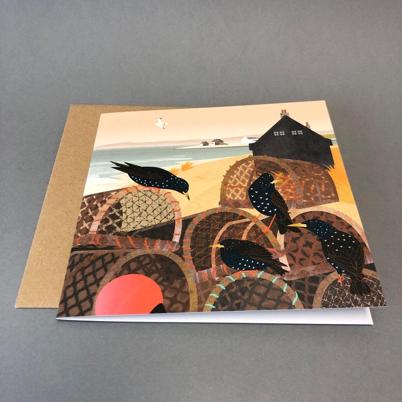 May include: A greeting card with a colorful illustration of a beach scene with a small house, a sandy beach, and four black birds perched on top of woven baskets. The birds are looking at each other and the baskets are stacked on top of each other.