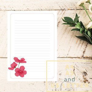 May include: A blank lined sheet of paper with a pink flower design in the bottom left corner. The paper is on a white wooden background. The text "A4" and "US Letter" is visible in the bottom right corner.