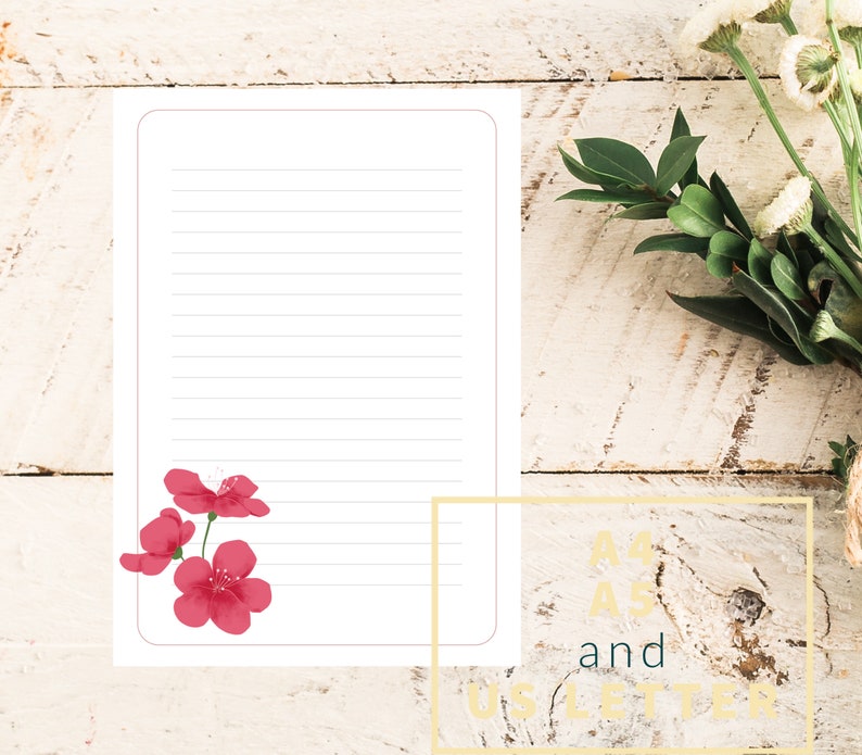 May include: A blank lined sheet of paper with a pink flower design in the bottom left corner. The paper is on a white wooden background. The text "A4" and "US Letter" is visible in the bottom right corner.