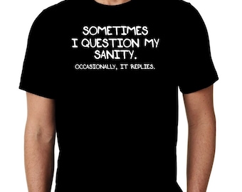 May include: Black t-shirt with the white text: "SOMETIMES I QUESTION MY SANITY. OCCASIONALLY, IT REPLIES." The shirt is a crew neck style and is being worn by a person.