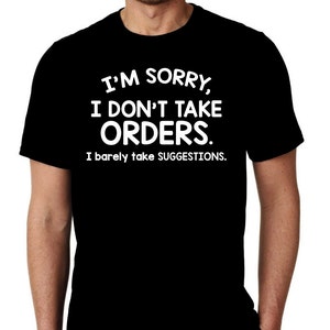 May include: Black t-shirt with white text that reads "I'M SORRY, I DON'T TAKE ORDERS. I barely take SUGGESTIONS." The shirt is a crew neck style and appears to be made of cotton or a similar material.