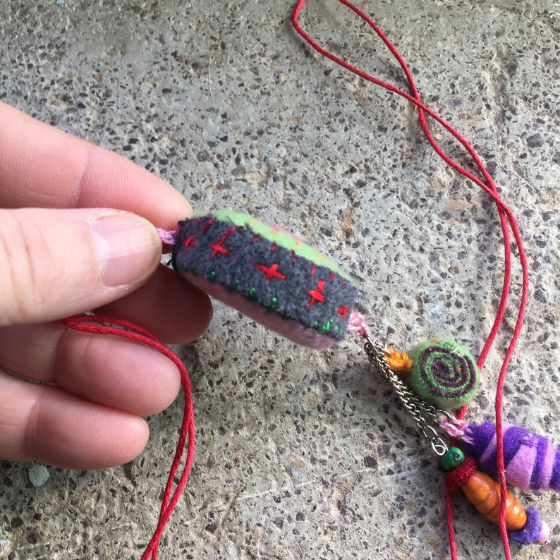 Collier sautoir au pendentif vert gris et rouge en laine brodée avec 3 breloques. Pour femme. image 3