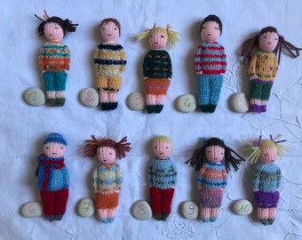 Small hand knitted dolls in wool, traditional toy. For children.