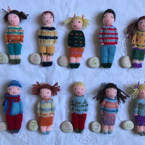 Small hand knitted dolls in wool, traditional toy. For children.