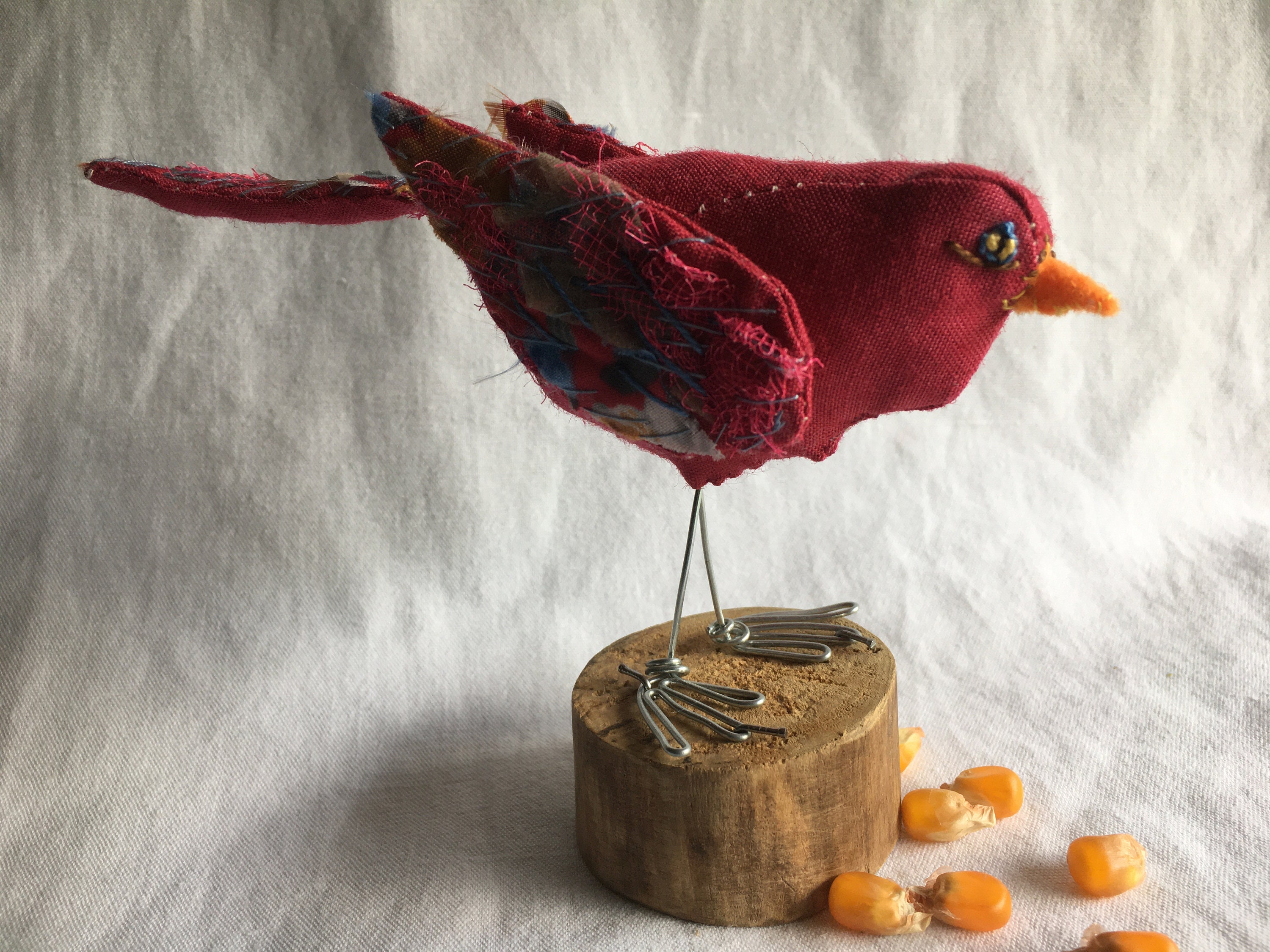 A small decorative bird in red sculpted fabric and embroidery, to pose. For the house.