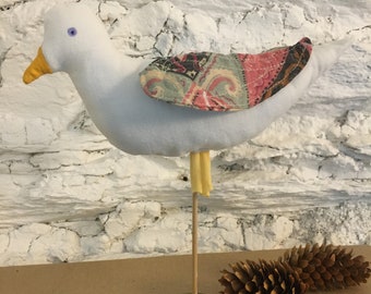 Oiseau décoratif à poser en tissus blanc et pastel.