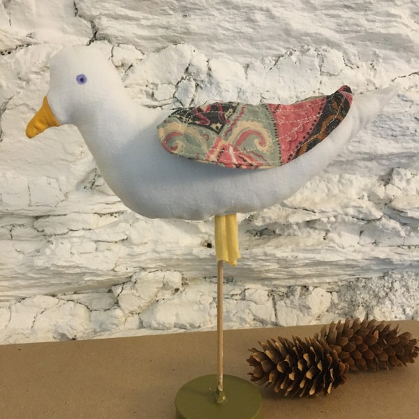 Oiseau décoratif à poser en tissus blanc et pastel.