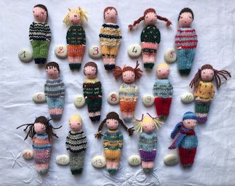 Small hand knitted dolls in wool, traditional toy. For children.