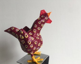 Petite poule de Pâques en papier sculpté rouge et jaune.