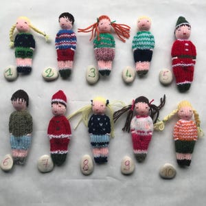 Small hand knitted boys and girls dolls in wool, traditional toy. For children.