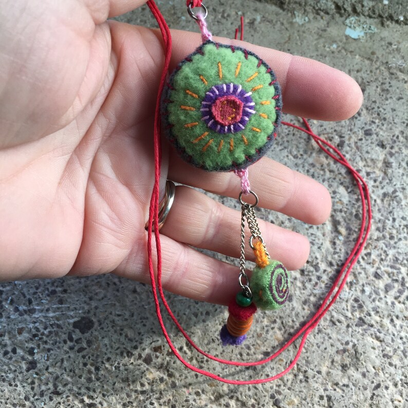 Collier sautoir au pendentif vert gris et rouge en laine brodée avec 3 breloques. Pour femme. image 2