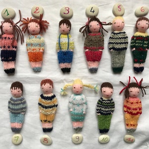 Small hand knitted dolls in wool, traditional toy. For children.