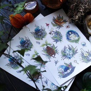 May include: Three sheets of paper with illustrations of various magical items, including a witch's hat, a book, a potion bottle, and a crystal. The illustrations are in a whimsical style with a blue, green, and purple color scheme.