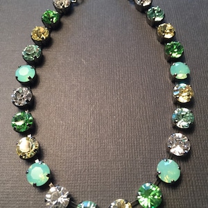 May include: A black chain necklace with a gradient of green, yellow, and clear round crystals.
