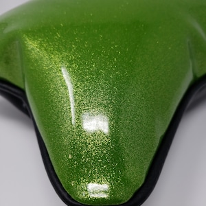 May include: A green star-shaped cushion with a glittery finish and black trim.