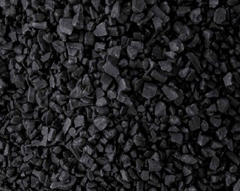 May include: Close-up of black lava salt crystals. The salt is coarse and has a rough texture.