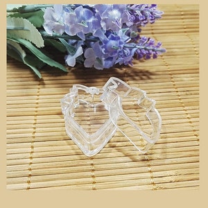 May include: Two clear plastic heart-shaped containers. The containers are stacked on top of each other.