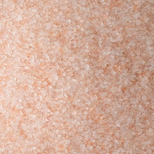 May include: Close-up of pink Himalayan salt crystals. The salt is a fine grain and has a light pink color.