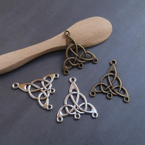 May include: Four silver and bronze Celtic knot triangle pendant charms. The charms have a three-dimensional design and are perfect for jewelry making.