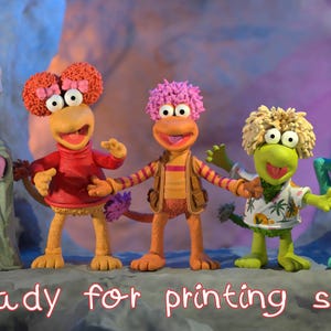 May include: Five colourful Fraggle Rock character figurines. The characters have distinct features, including various hair colours and outfits. The text "ready for printing stl file" is written in a cursive font at the bottom of the image.