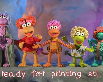 May include: Five colourful Fraggle Rock character figurines. The characters have distinct features, including various hair colours and outfits. The text "ready for printing stl file" is written in a cursive font at the bottom of the image.