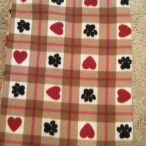 May include: A white and brown plaid fabric with red hearts and black paw prints.