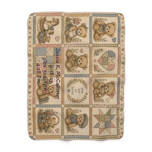 May include: A rectangular woven blanket featuring a patchwork design of teddy bears, hearts, and stars in muted beige, blue, and pink tones. The text reads: Jessie K. McCallister, 9-18-27, 9lbs. 5oz, 17in, 4:28 P.M., and you are so loved.