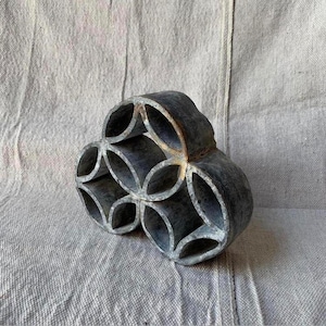 Könnte beinhalten: Eine graue Metallform mit geometrischem Design. Die Form ist wie eine Blume mit mehreren Blütenblättern geformt.