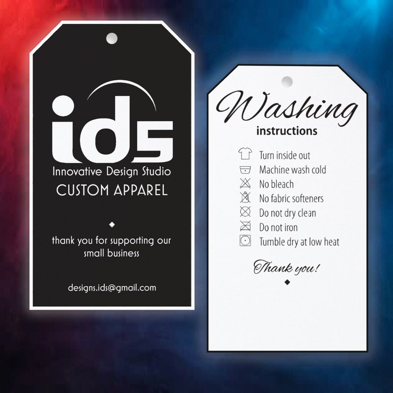 May include: Two clothing tags, one black and one white, with text. The black tag features the logo "ids" and the words "Innovative Design Studio CUSTOM APPAREL". The white tag displays washing instructions and the words "Thank you!"