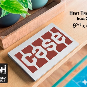 May include: A rectangular heat transfer with the word "CASE" in white, set against a red background. The image size is 9 5/8 x 4 7/8 inches. A CNH Industrial licensed product logo is in the lower left corner.