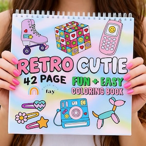 May include: A spiral-bound coloring book with the words "Retro Cutie" in pink and white. The cover features illustrations of a roller skate, Rubik's cube, cell phone, camera, and other retro-themed images. The text "42 Page Fun + Easy Coloring Book" is also displayed.