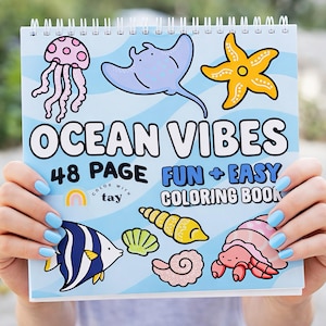 May include: A spiral-bound coloring book titled "Ocean Vibes" with illustrations of sea creatures like a jellyfish, stingray, starfish, and fish. The cover also features the text "48 PAGE FUN + EASY COLORING BOOK".