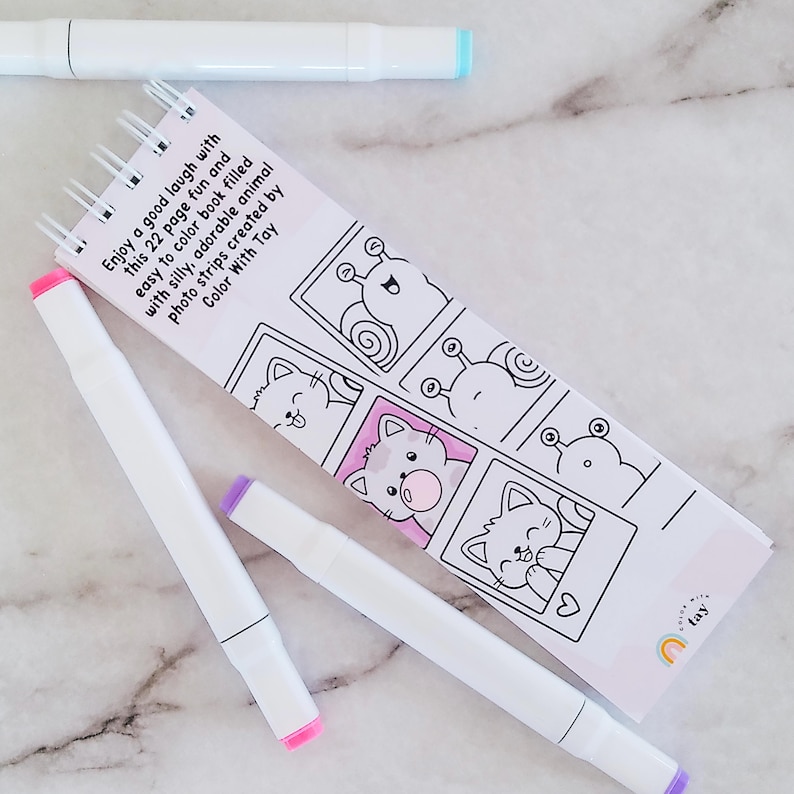 May include: A spiral-bound 22-page coloring book featuring black and white line art of animals in photo strips, with the text 'Enjoy a good laugh with this 22 page fun and easy to color book filled with silly, adorable animal photo strips created by Color With Tay'. Three white markers with colored caps are placed around the book.