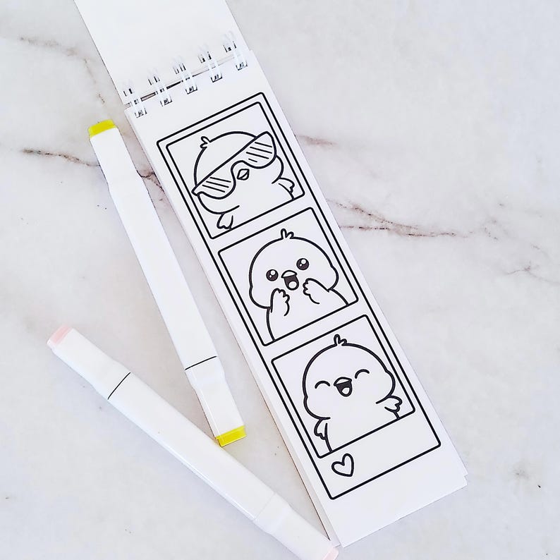 May include: A spiral-bound coloring pad featuring three vertical black and white illustrations of a small bird character in different poses, accompanied by two white markers with yellow and light pink caps respectively.