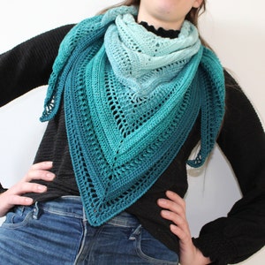 Peut inclure: Un châle en crochet ombré turquoise, vert et bleu avec un motif ajouré.
