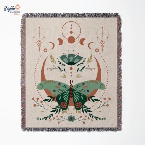 May include: A woven tapestry featuring a green butterfly with floral accents, surrounded by a crescent moon and geometric shapes in shades of brown and orange.