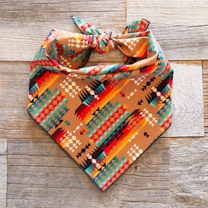 May include: A brown bandana with a colorful geometric pattern featuring triangles, diamonds, and stripes in shades of red, orange, yellow, blue, and green.