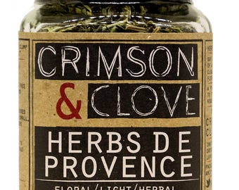 May include: A glass jar filled with dried herbs labeled "Crimson & Clove Herbs de Provence" with the text "Floral/Light/Herbal" and "#JustSpice Net Wt. 1.00 oz".