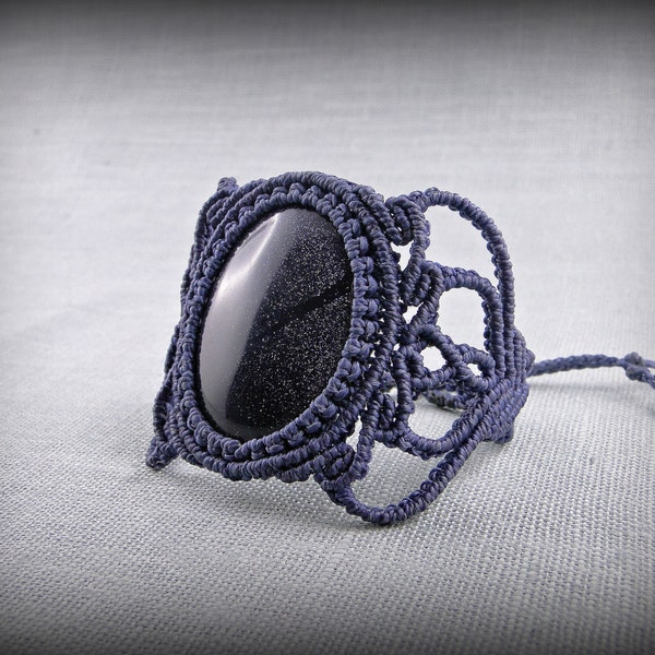 Bracelet macramé avec un cabochon de verre bleu. Pierre de soleil bleue synthétique. Perles argentées. Petit bracelet. pierre pailletée.