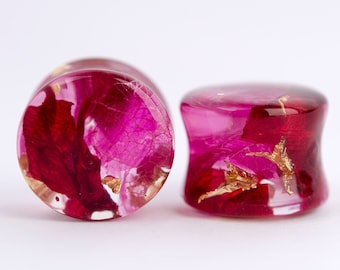 May include: A pair of pink and red resin ear gauges with gold leaf accents and dried flower inclusions.