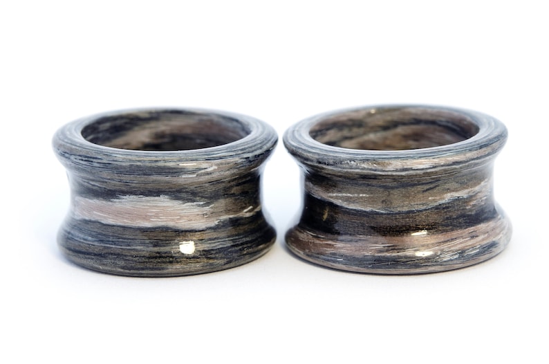 May include: Two gray and brown striped wooden rings. The rings are smooth and have a glossy finish.