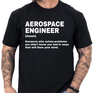 May include: Black t-shirt with white text that reads "AEROSPACE ENGINEER (noun) Someone who solves problems you didn't know you had in ways that will blow your mind."